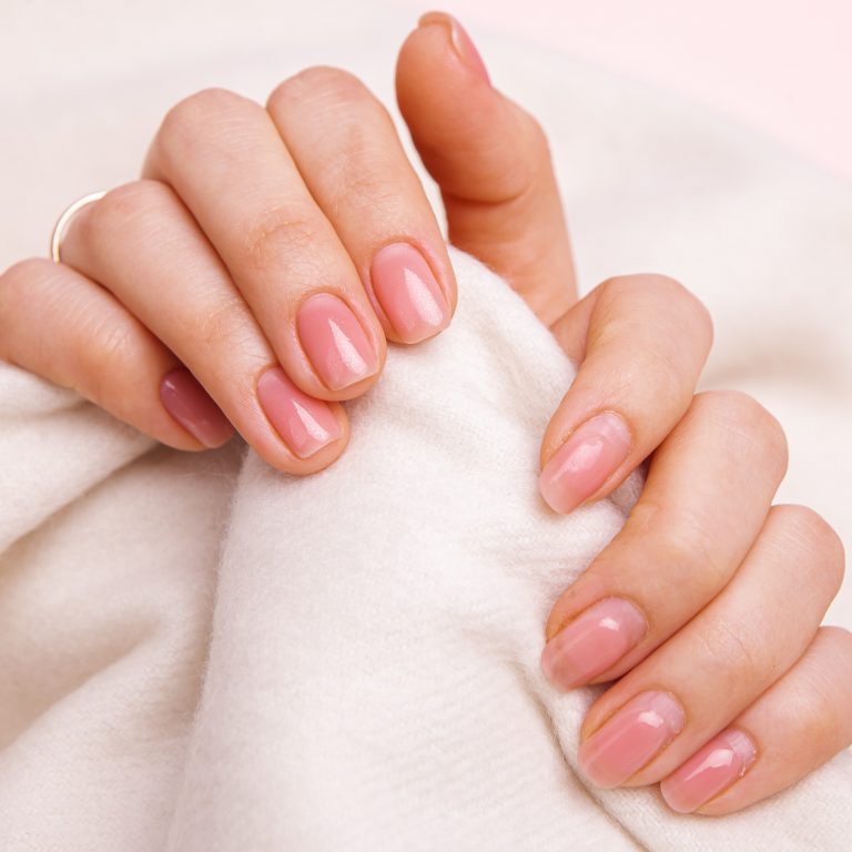 the hands of a girl with nails well-groomed and untidy and regrown with gel polish and covered with gel polish.